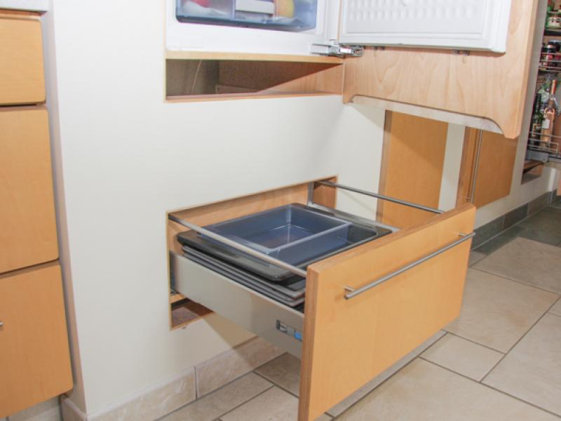 Kühlschrank und ausziehbare Stauraum-Schublade in die Wand integriert, rechts: Vorratsauszug